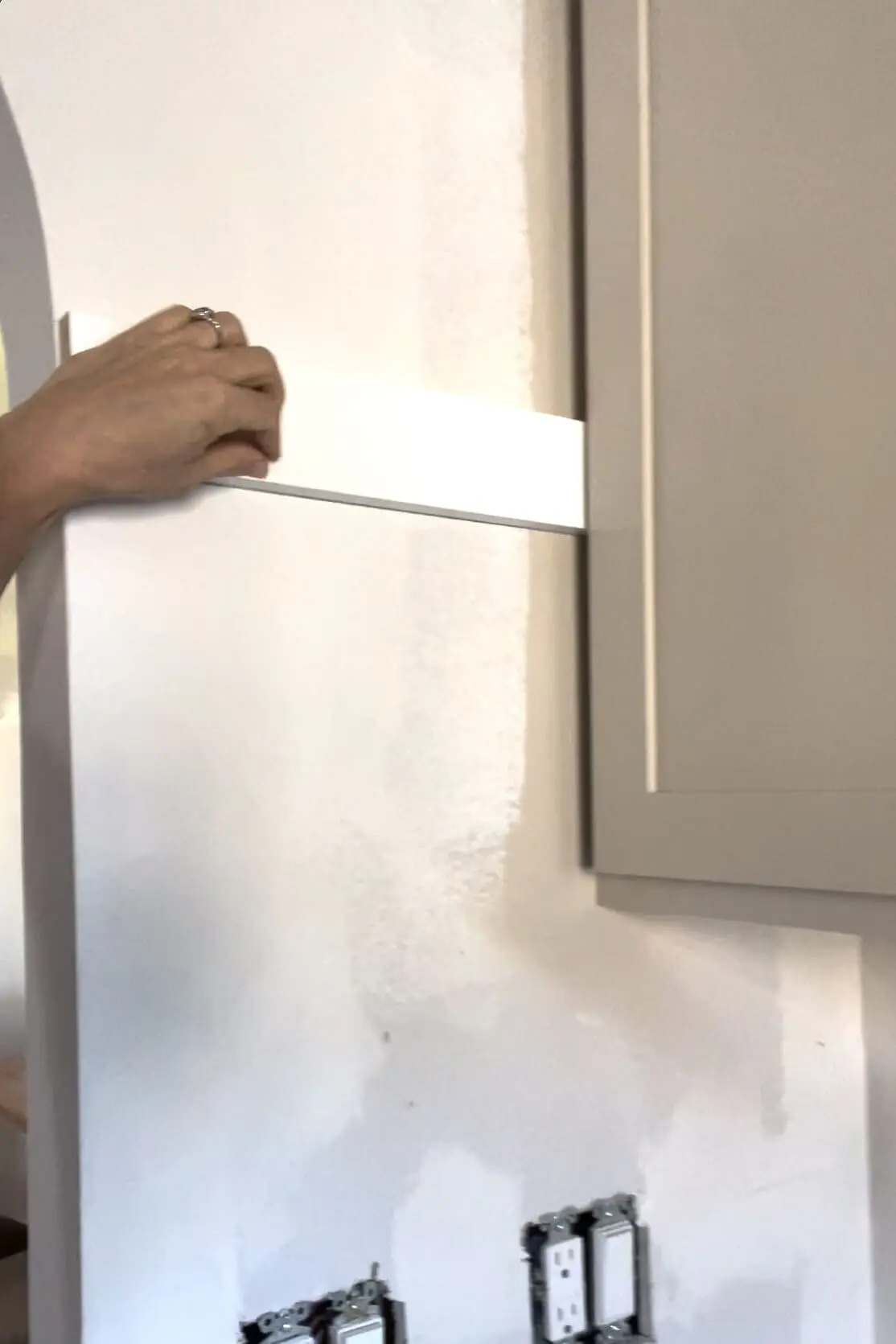 Installing a DIY shiplap backsplash.